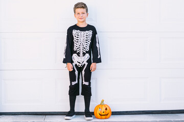 Boy in Halloween costume with pumpkin