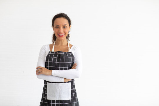 Portrait of smiling young woman in apron  looking at camera isolated on white background