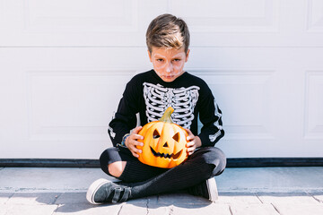 Boy in Halloween costume with pumpkin