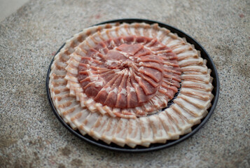 Various types of pork are sliced ​​thin and arranged on a tray.