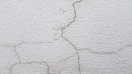 Cracks on the white plaster wall.