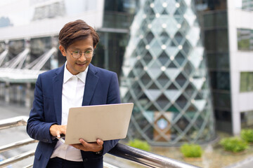 Handsome asian businessman working outdoors with computer