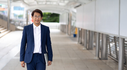 Portrait asian businessman wearing suit jacket walking go to work in morning outdoor.