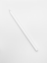white stylus pen on a white background. a pen to draw or create something on tablet or phone. creating illustration as it's on paper using modern technology.