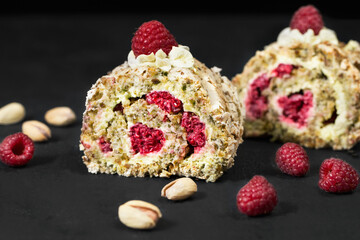 Dacquoise with raspberries and pistachios. French cake. Dessert with berries. Macro photo of the dessert. French food on a black background. Pistachio biscuits.