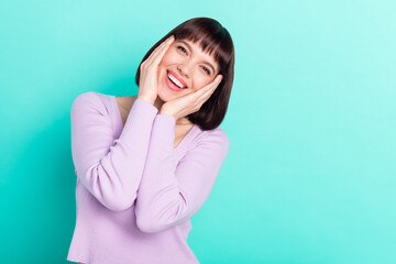 Photo portrait woman with bob hair touching cheeks overjoyed happy isolated vibrant teal color background