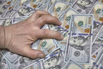 hand clutching money, the concept of greed