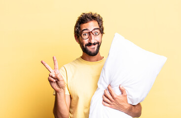 expressive crazy man smiling and looking happy, gesturing victory or peace and holding a pillow