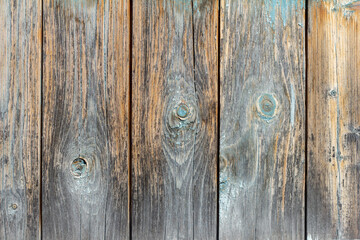 Obraz premium Wooden background.An old wooden fence made of unpainted boards with cracks and nails.
