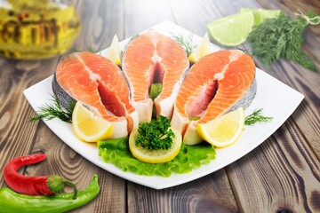 Fresh raw fish Fillets on a plate with lemon and parsley.