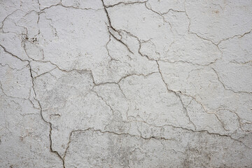 Fototapeta premium White Concrete Wall With Cracks Along Surface