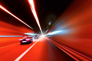 Cars rush through the tunnel in the beams of searchlights. Motion effect.