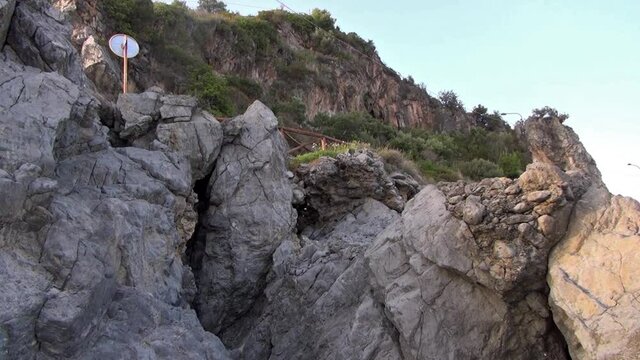 Mountain road along the promenade and rocks on the slope below.