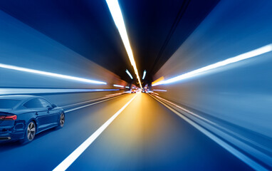Fototapeta na wymiar Cars rush through the tunnel in the beams of searchlights. Motion effect.