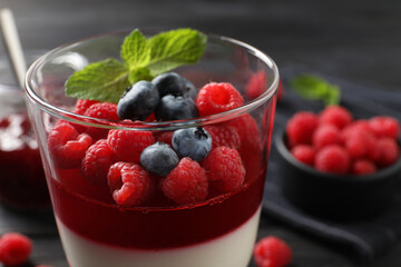 Delicious panna cotta with berries in glass dish, closeup