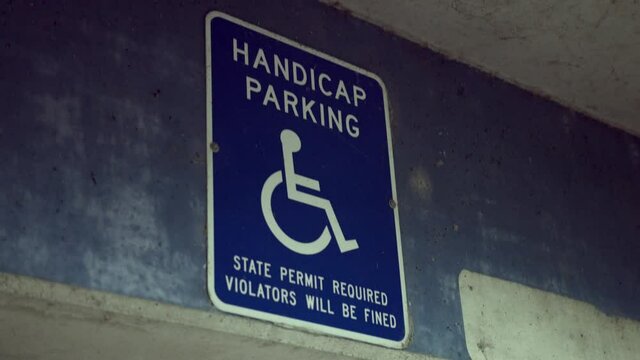 Handicap Parking Sign On The Concrete Wall Of A Parking Garage. close up