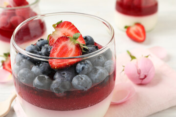Delicious panna cotta with berries in glass dish, closeup
