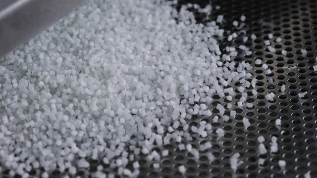 Plastic granules on a vibrating table. Polymer compound production