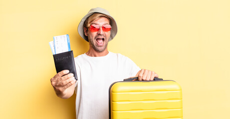 expressive crazy bearded man on hollidays holding a suitcase