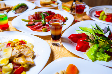 Alcohol drink shot and snacks on table in bar