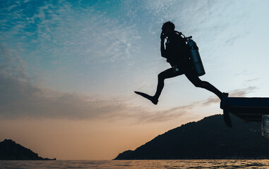 Scuba Diver Jumping to the open ocean on a sunrise morning