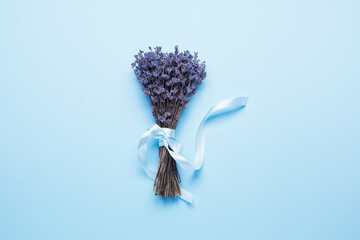 Lavender bouquet with ribbon on a blue background.
