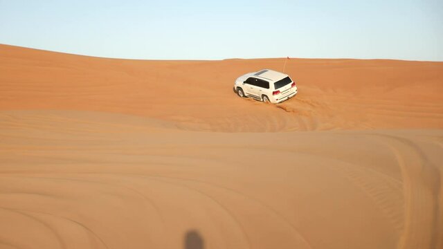 4x4 off road vehicle taking tourists on desert dune bashing safari in Dubai, UAE. View Of Sports Cars Dune Bashing. Desert safari Dubai.
