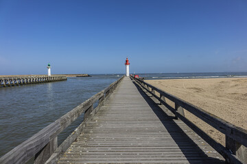 Obraz premium Entrance of the Trouville port. Red Lighthouse tower on the seacoast. Trouville, Calvados department, Normandy, France.