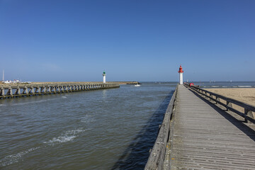 Entrance of the Trouville port. Red Lighthouse tower on the seacoast. Trouville, Calvados department, Normandy, France.