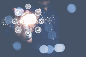 Businessman holding light bulb with virtual earth and cloud computing inside copy space and with business icons. Creative idea design innovation technology for business to the future.