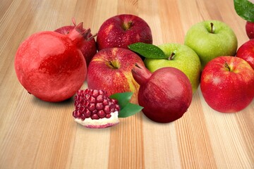 Pomegranates and red apples on the desk, traditional food of Jewish New Year