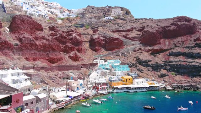 Santorini, Greece: Aerial view of Oia, famous village with iconic white houses on Thira (Thera) island, caldera cliffs towering over Mediterranean Sea - landscape panorama of Europe from above