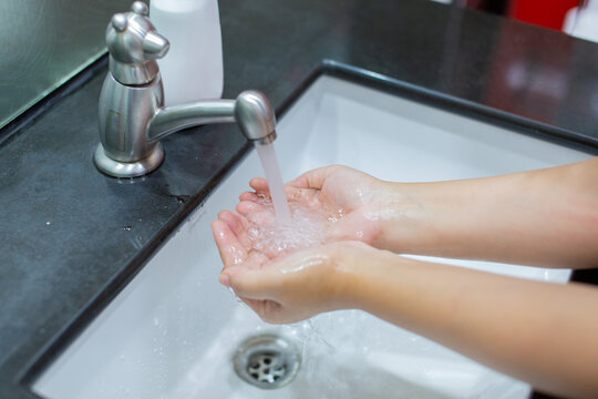 A Woman Holding Hands In A White Sink