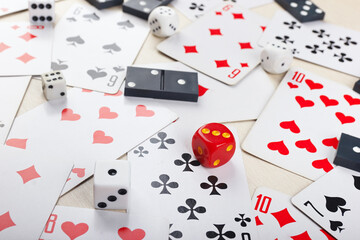 Dice, dominoes and playing cards for board games on table close up.