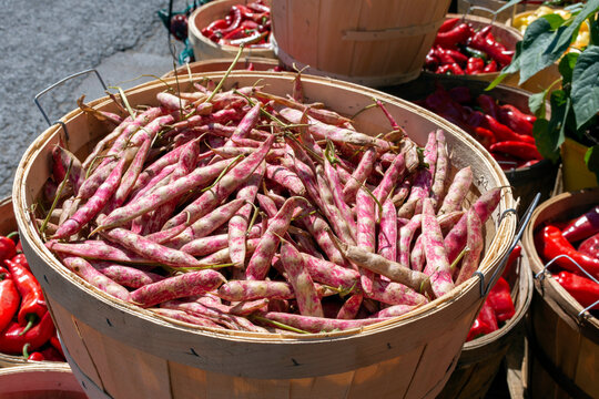 Pink and white Borlotti or cranberry beans are seen with red peppers at the market.