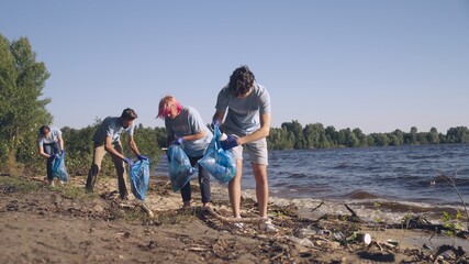 Environmentally conscious volunteers cleaning beach from trash nature protection © Synthex
