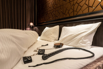 ベッドに置かれた鞭と手枷　SMプレイのイメージ　whip and collar on the bed