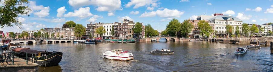 Amsterdam in Holland, die Kanäle mit Booten und blauer Himmel, Panorama.