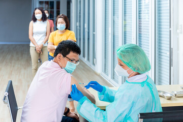 Obraz premium medicine, vaccination and healthcare concept - doctor wearing face protective medical mask for protection from virus disease with syringe doing injection of vaccine to a patient