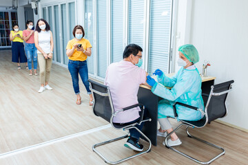 medicine, vaccination and healthcare concept - doctor wearing face protective medical mask for protection from virus disease with syringe doing injection of vaccine to a patient