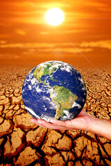 Hand holding a globe on dry land. concept of global warming and environment and change