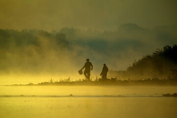 Wędkarze nad rzeką o wschodzie słońca