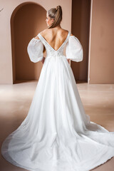 Fototapeta premium Perfect bride, portrait of a girl in a long white dress. Beautiful hair and clean delicate skin. Wedding hairstyle blonde woman. 