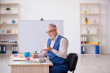 Old male designer working in the office
