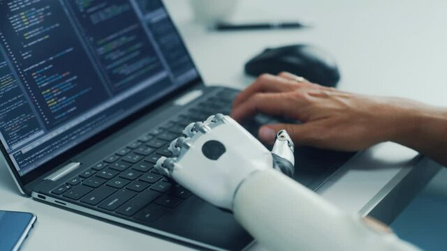 Close-up on Hands: Programmer With Disability Using Prosthetic Arm to Work on Laptop Computer. Specialist Swift and Natural Use of Myoelectric Bionic Hand To Type Code for Software