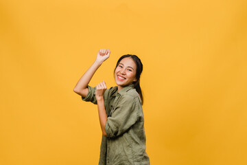 Young Asia lady with positive expression, joyful and exciting, dressed in casual cloth over yellow...
