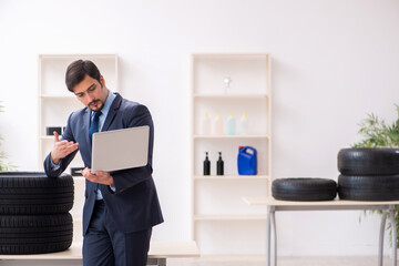 Young man selling tires in the office