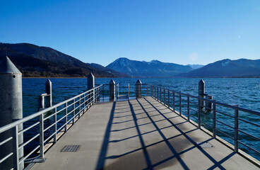 a beautiful view from a pier on lake Tegernsee in Bavaria with the wintery Alps in the background on a sunny December day (Bavaria in Germany)	