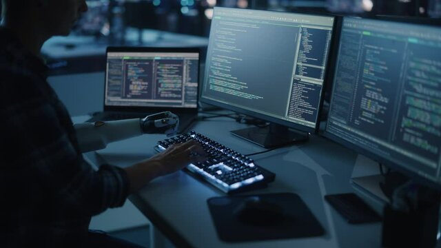 Night Office: Programmer With Disability Using Prosthetic Arm to Work on Computer Keyboard. Swift and Natural Use of Myoelectric Bionic Hand To Type Code for Software at Night. Medium Arc Shot