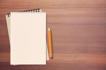 White empty notebooks and yellow pencil on the desk